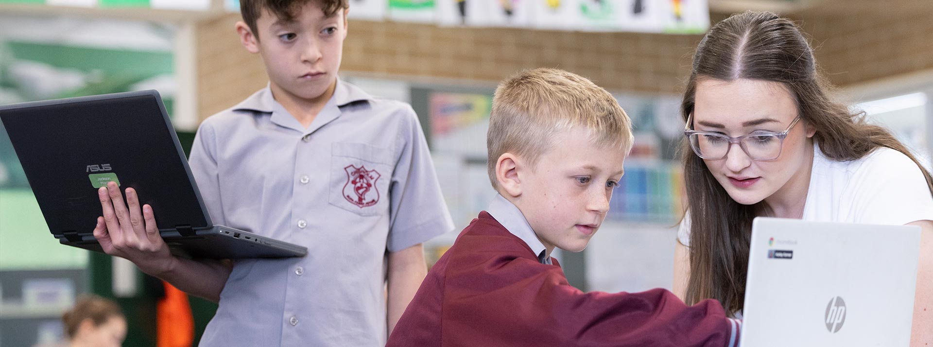 Chisholm Catholic Primary, Bligh Park students in class, the teacher is assisting the students