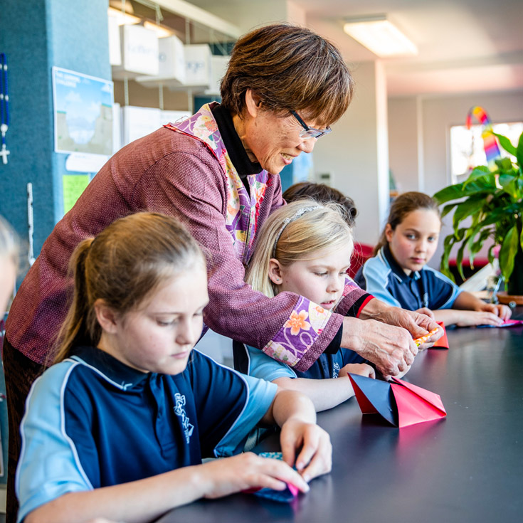 Catholic Schools Parramatta Diocese teacher assisting students in art class