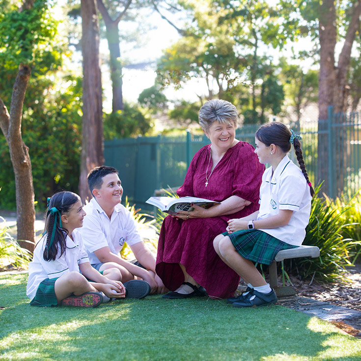 Corpus Christ Catholic Primary Creanbrook Religious Education teacher with students in garden