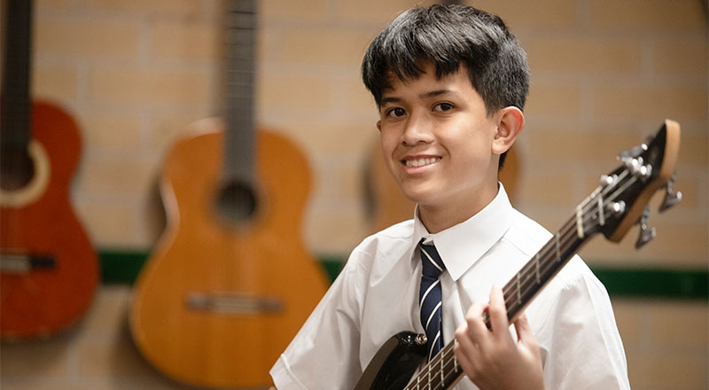 Emmaus Catholic College student playing bass guitar