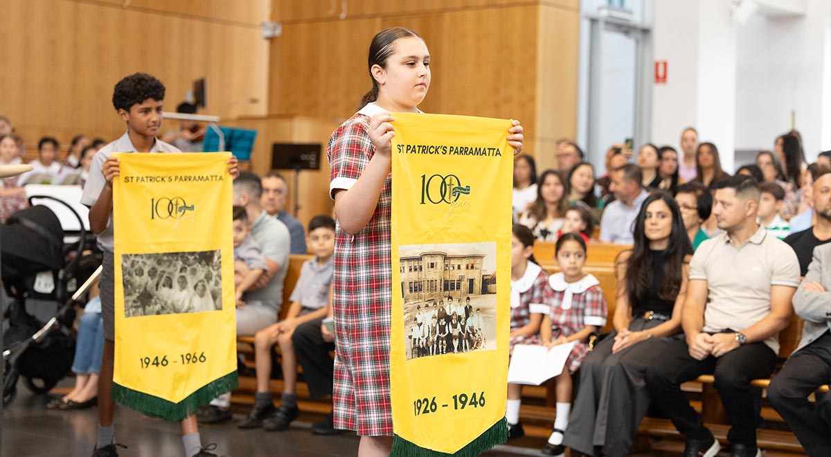 St Patrick's Primary Parramatta students carrying banners which show the history of the school throughout different time periods 