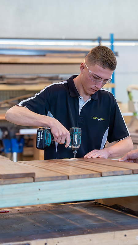 Kalan Markson working on his carpentry using a power tool